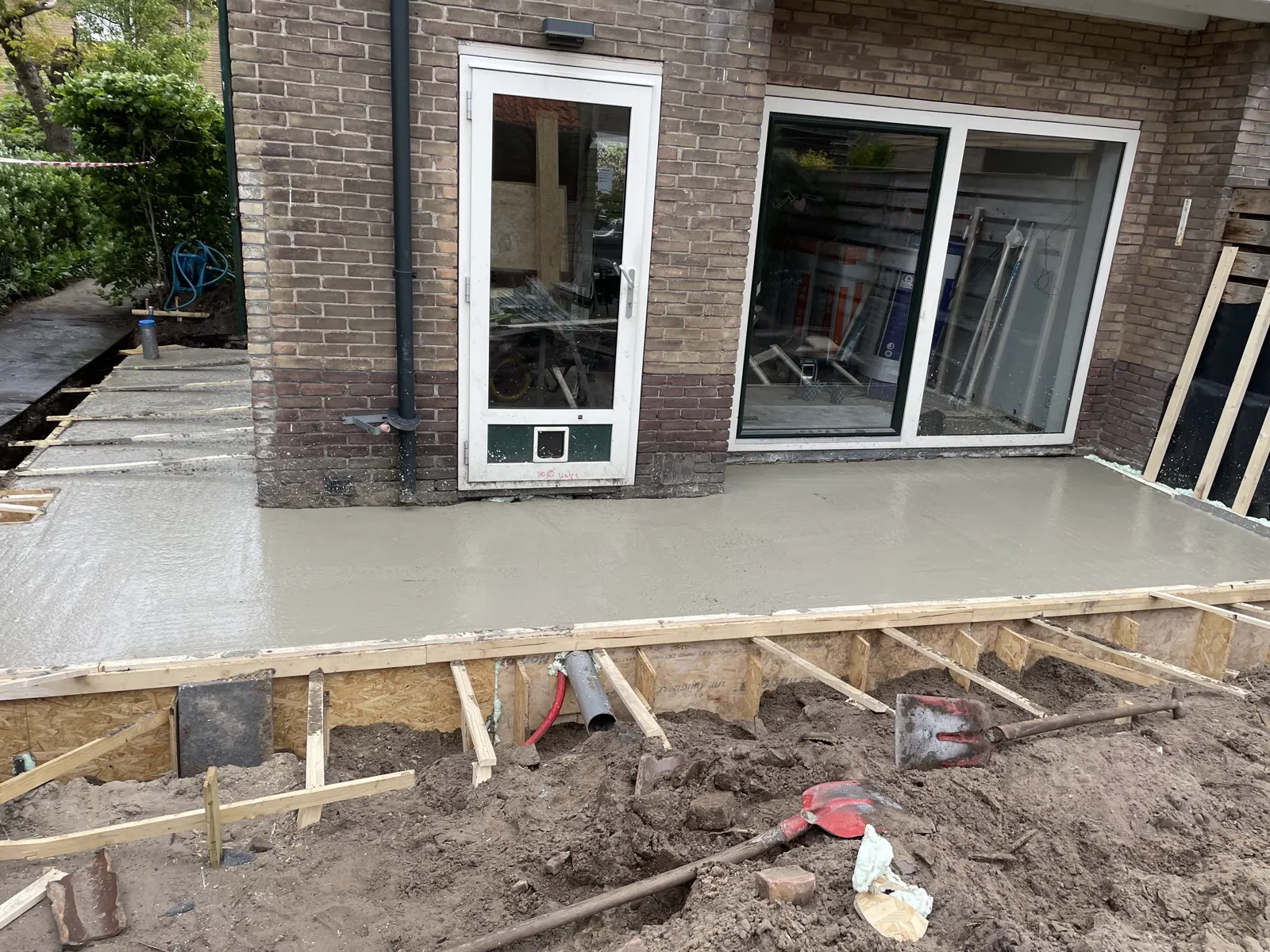 Fundering en betonvloer van een aanbouw, met het stelkozijn al geplaatst