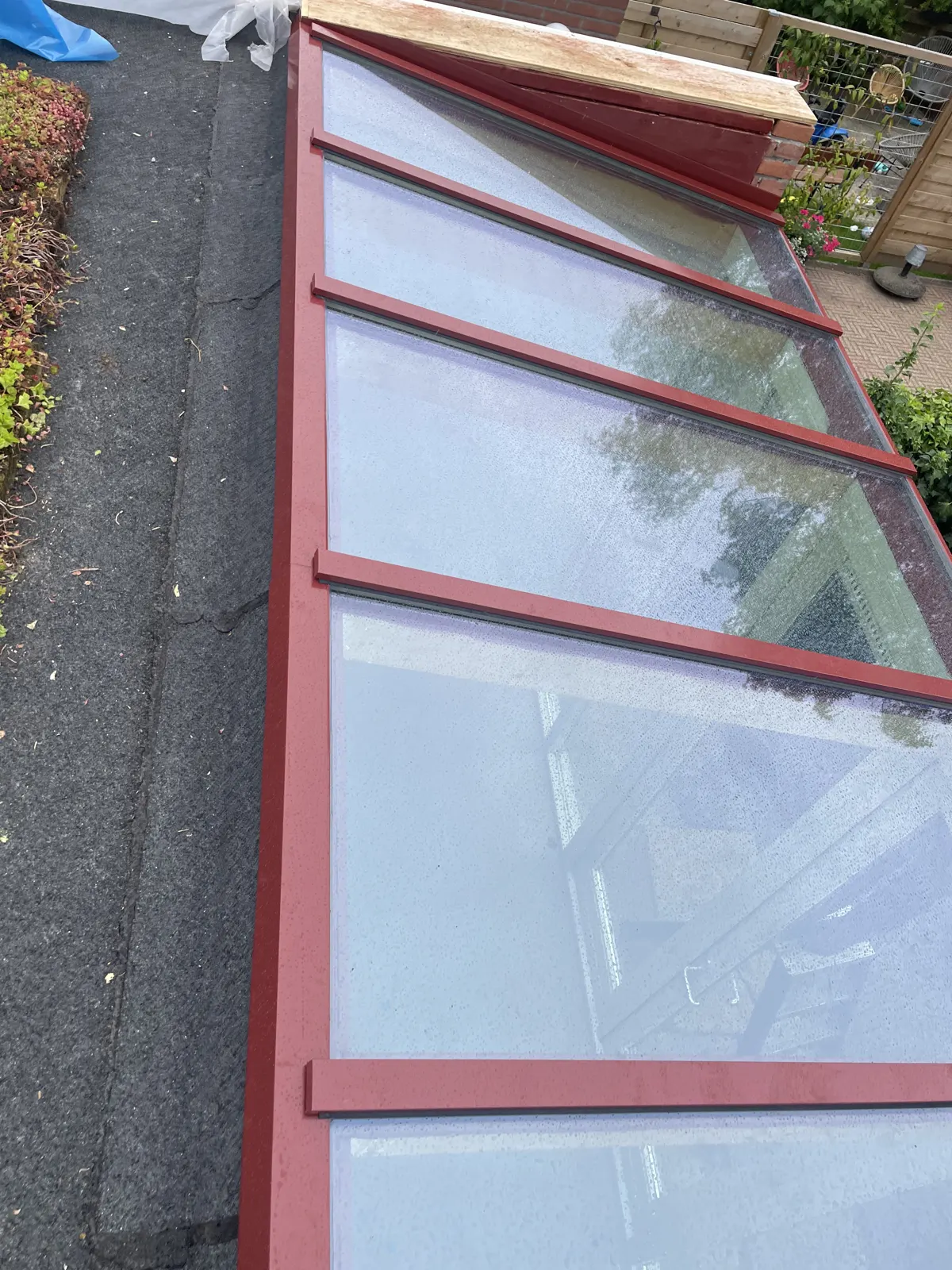 Glazen daklicht in een donker kozijn, detail van het glas