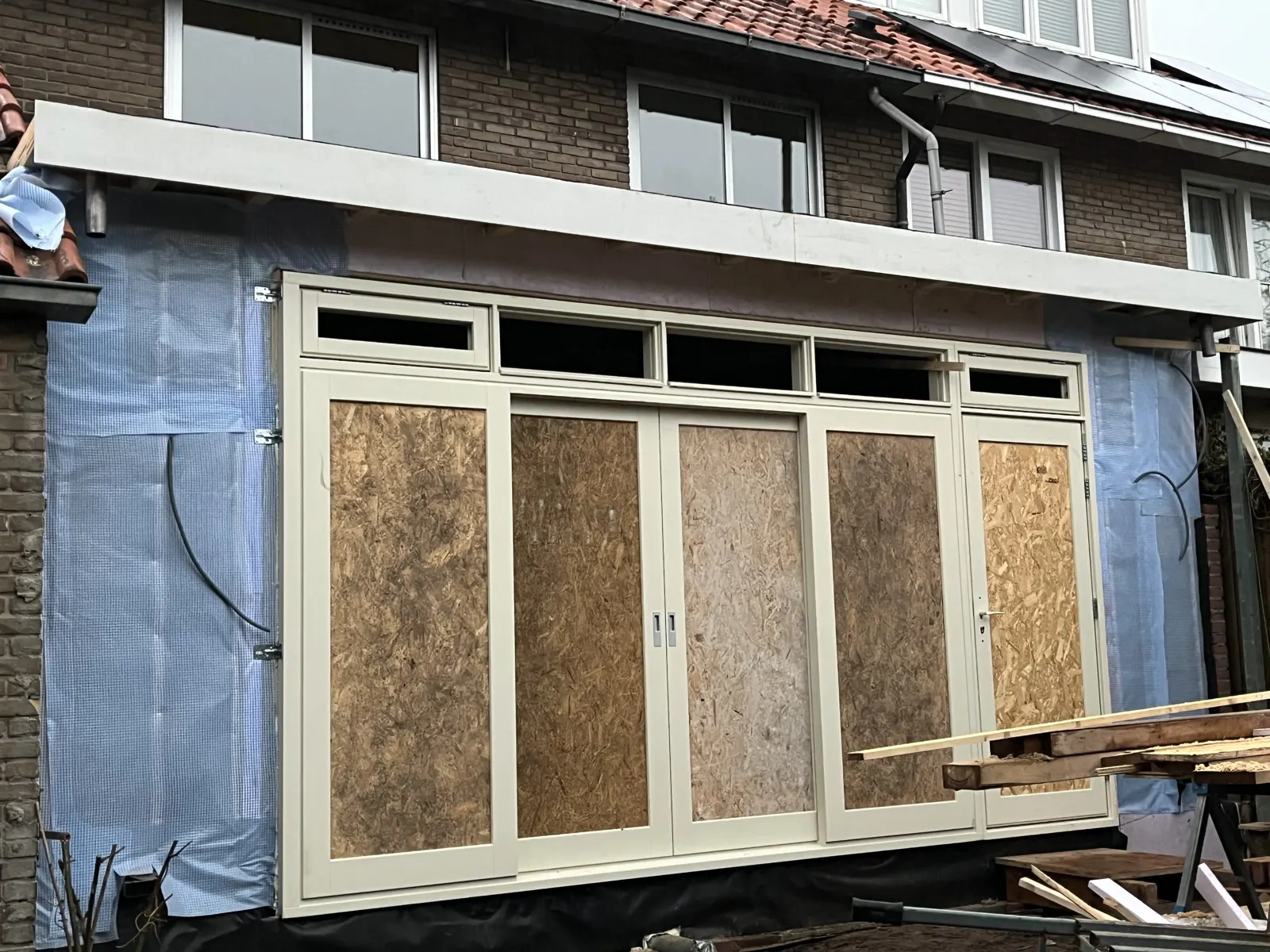 Nieuwe kozijnen tijdens de montage, tijdelijk afgedekt met plaatmateriaal