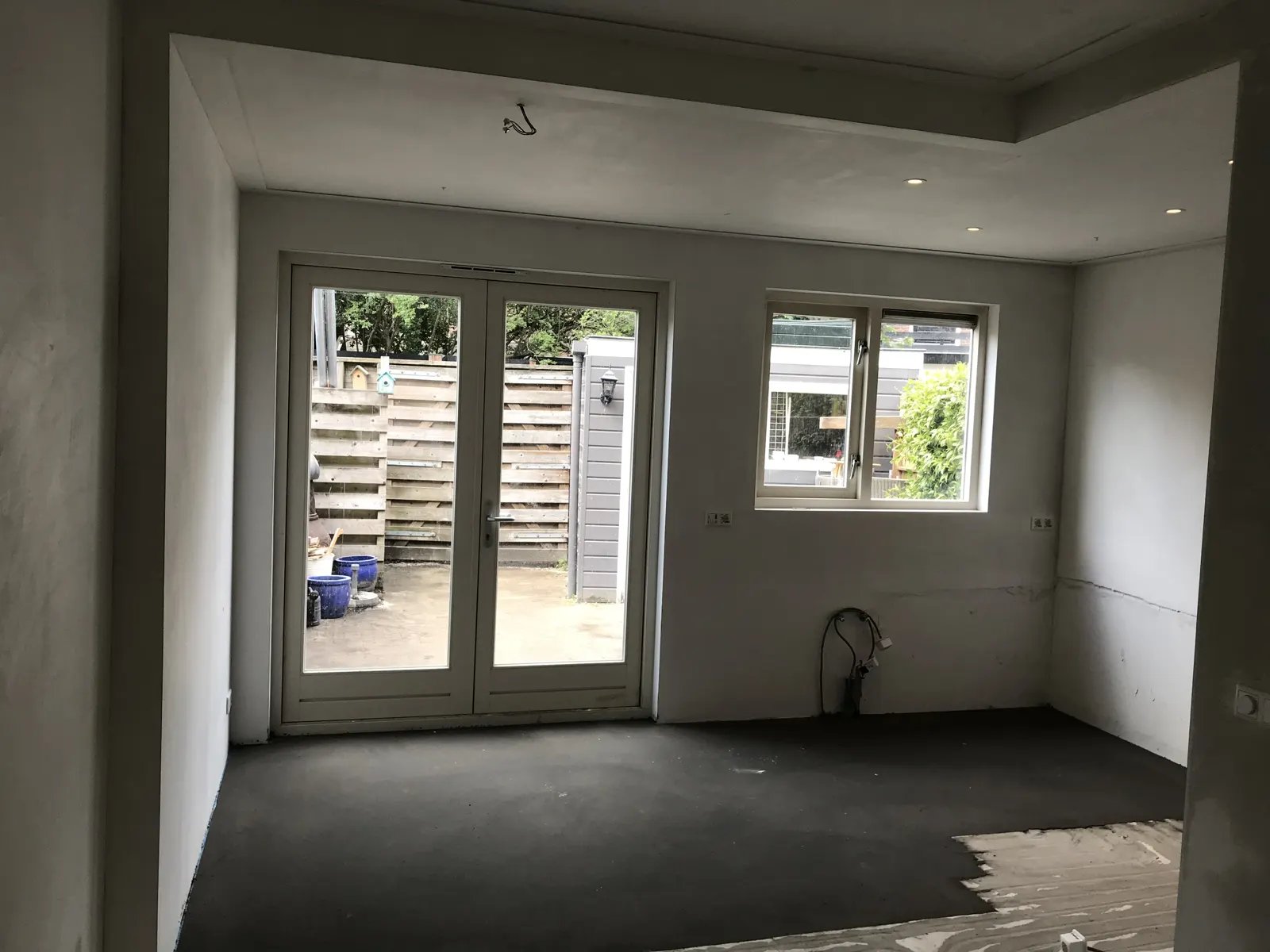 Nieuwe tuindeuren in een verbouwde kamer, nog zonder vloerafwerking