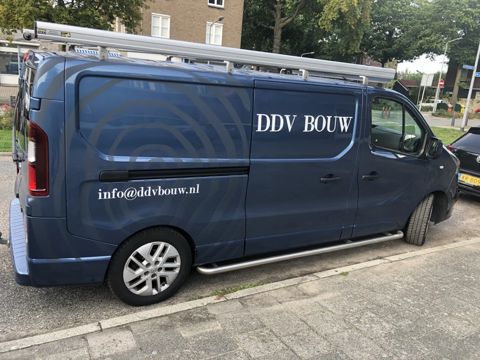 Blauwe werkbus van DDV Bouw met logo en het e-mailadres info@ddvbouw.nl