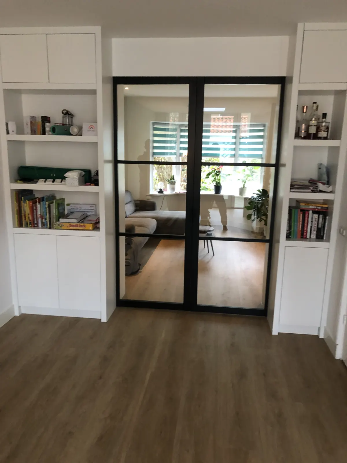 Inbouwkasten naast een glazen pui in een verbouwde kamer