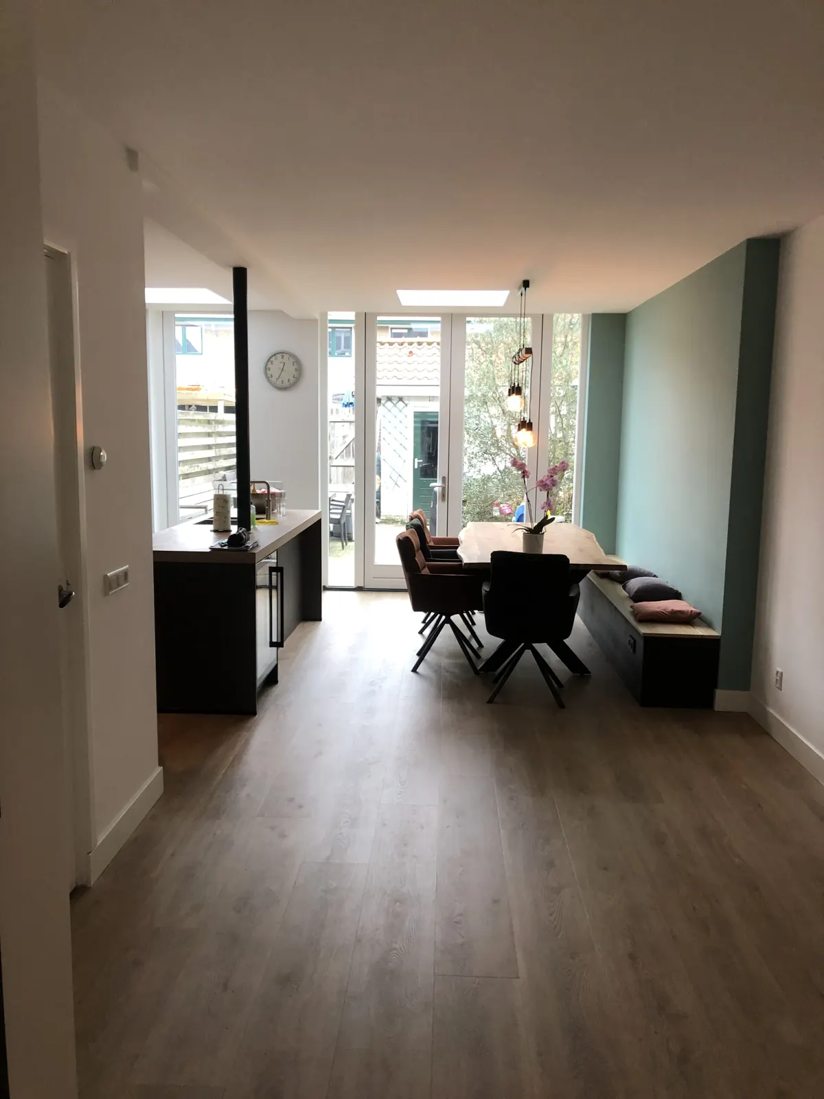 Doorkijk door een verbouwde woning naar de keuken en de tuin