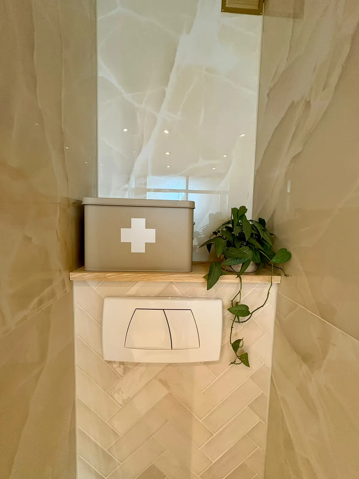 Toiletnis met visgraattegels, houten planchet en een inbouwreservoir