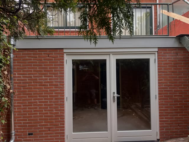 Opgeleverde bakstenen uitbouw met openslaande deuren in Naarden